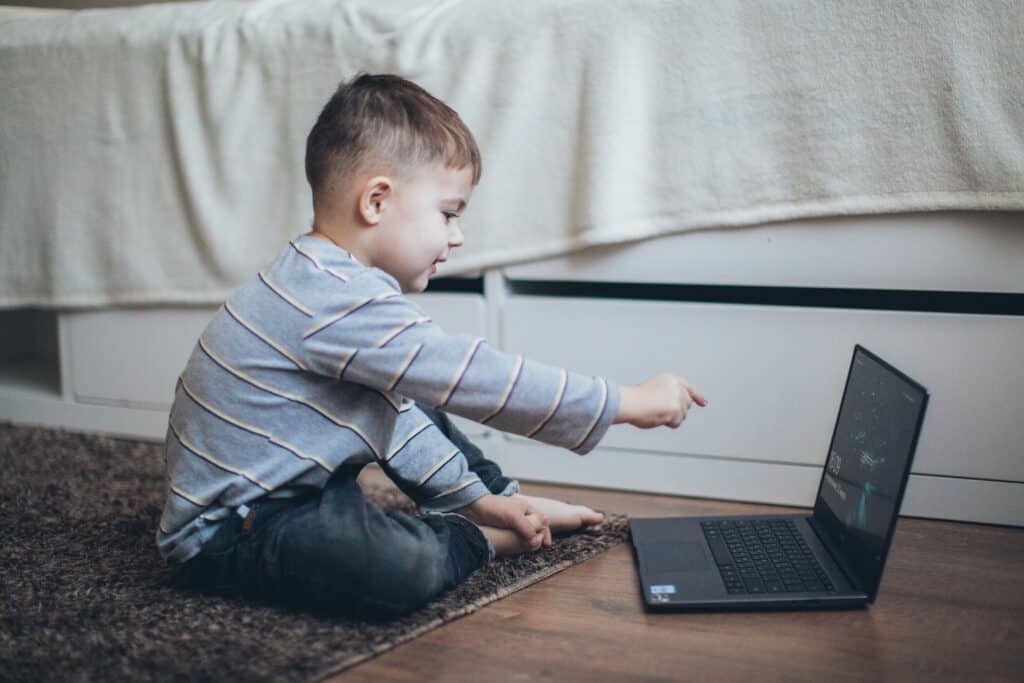child pointing at laptop