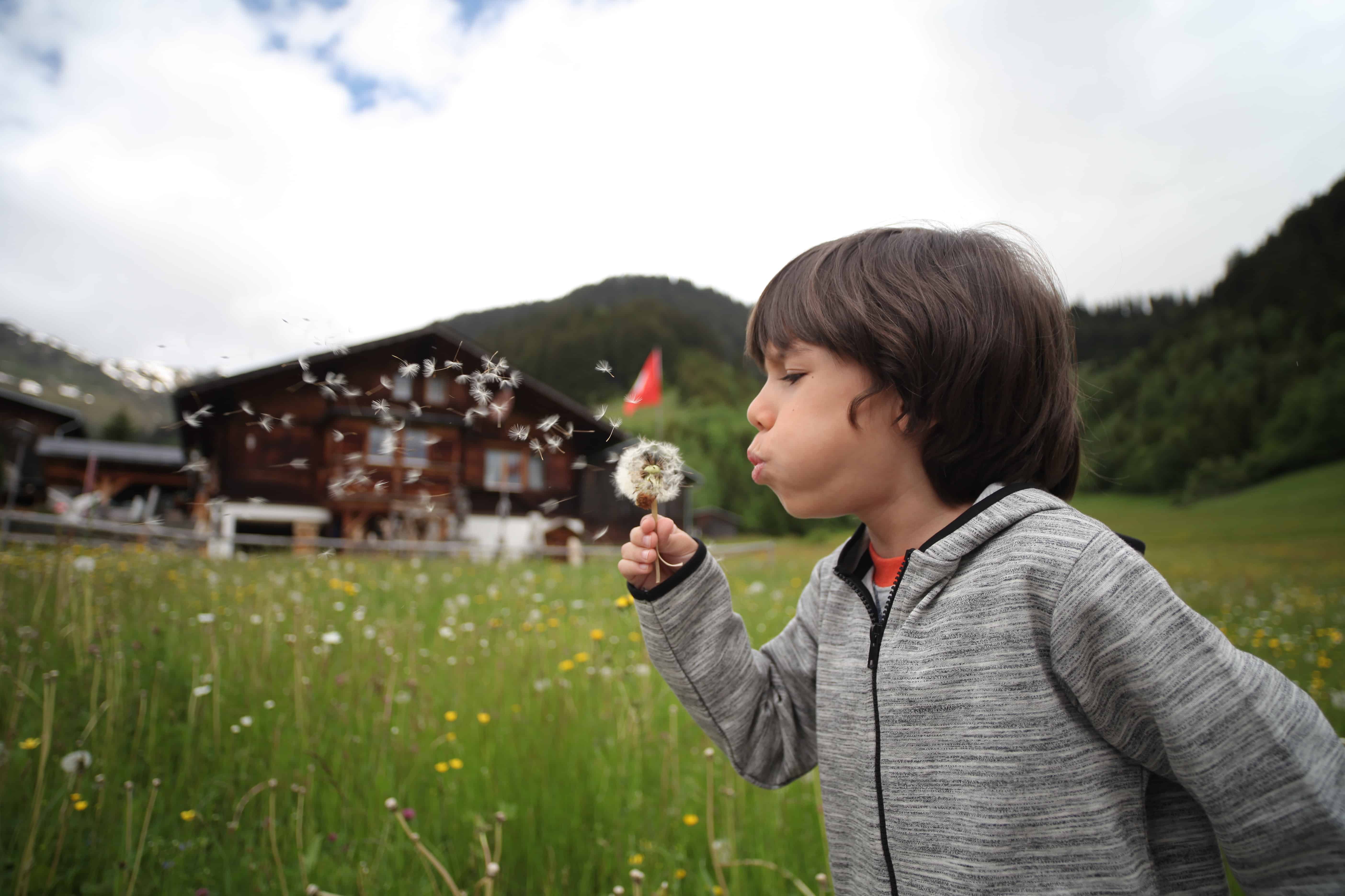 boy blowing bubbles outside
