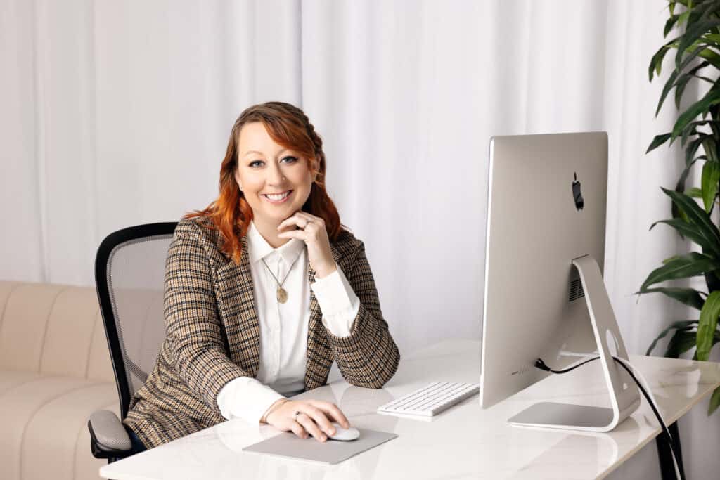 Beth McCarter head shot, working at a desk